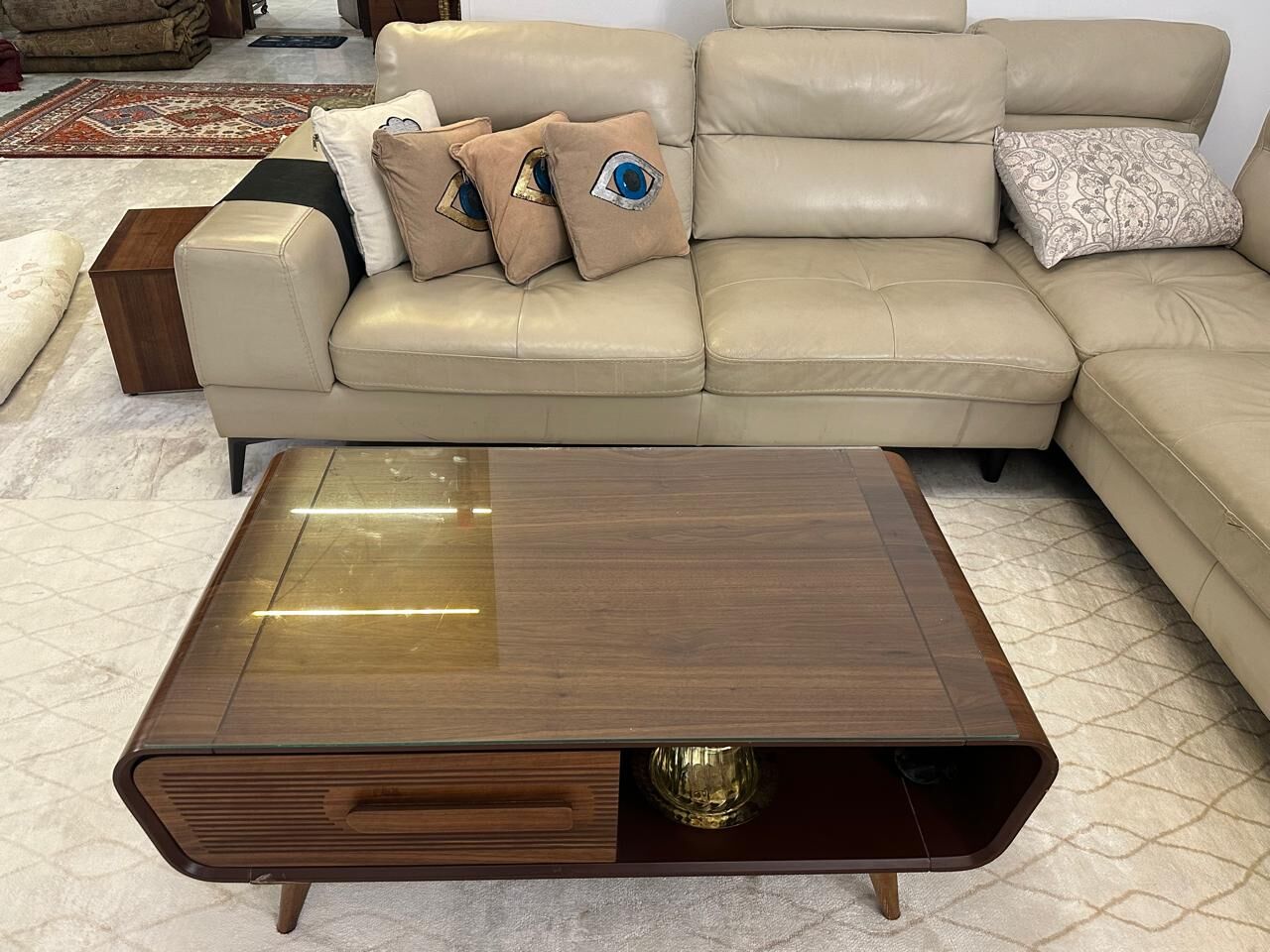Leather corner sofa with cushions and a wooden coffee table on a cream rug